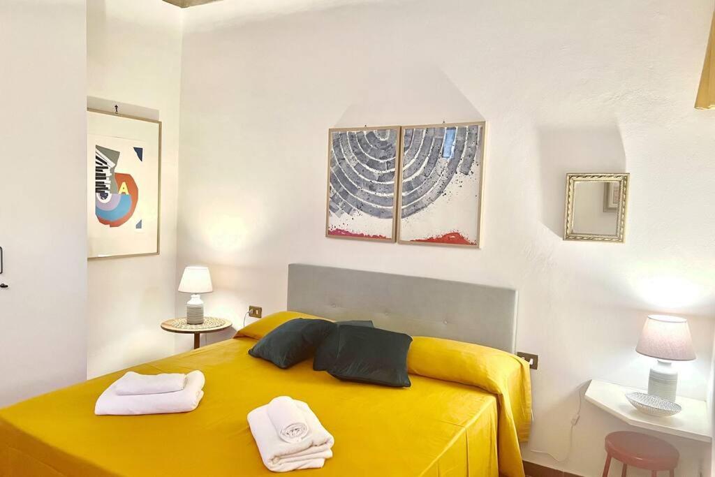una camera da letto con un letto giallo con due asciugamani di Sweet Home Florence a Firenze