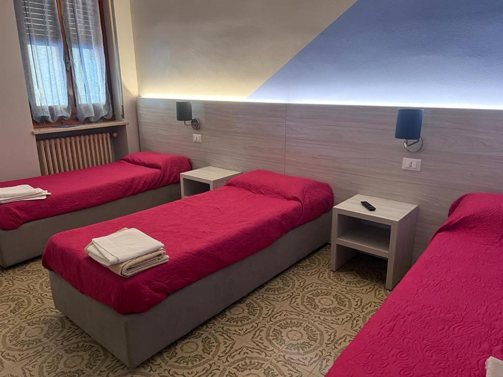 3 Betten in einem Zimmer mit roter Bettwäsche in der Unterkunft Cannone d'Oro in Sale