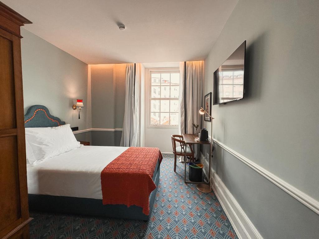 ポルトにあるGRANDE HOTEL PARIS by STAY HOTELSのベッドと窓が備わるホテルルーム