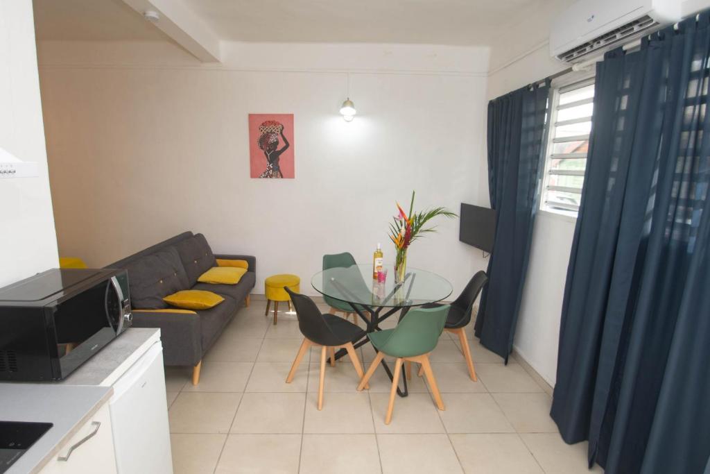 sala de estar con mesa y sofá en La Kalenda - Studio climatisé, en Saint-Pierre