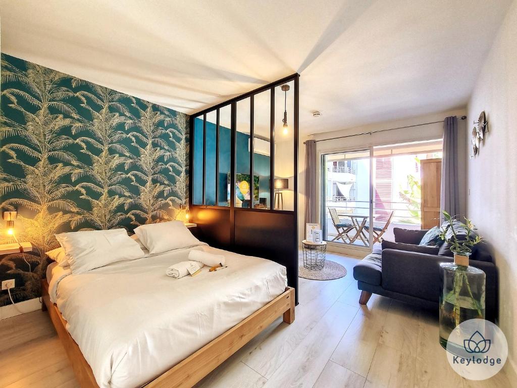 a bedroom with a large bed and a couch at Manoa - Studio classé 2 étoiles à Saint-Denis in Saint-Denis