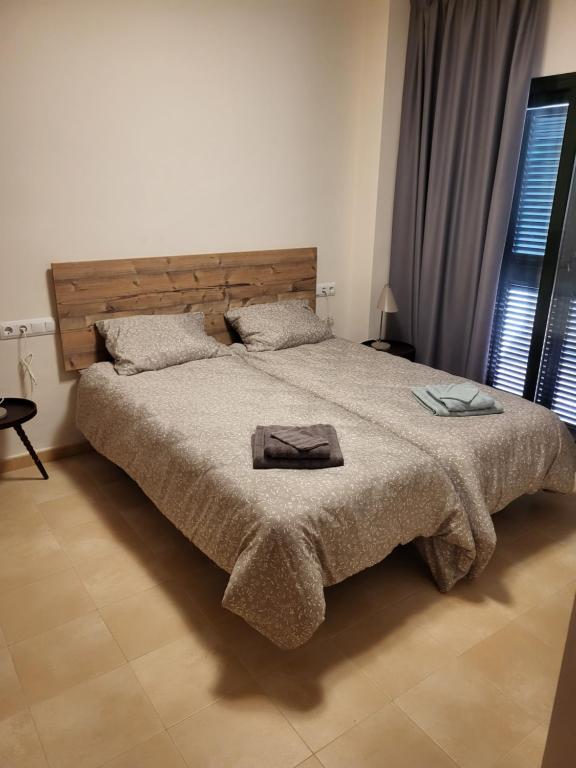 - une chambre avec un grand lit et une tête de lit en bois dans l'établissement Hacienda de Alamo / Casa Veraneo, à Fuente-Álamo de Murcia
