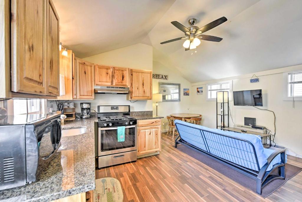 a kitchen with wooden cabinets and a ceiling fan at The Starfish Hampton Cottage Walk to Beach! in Hampton