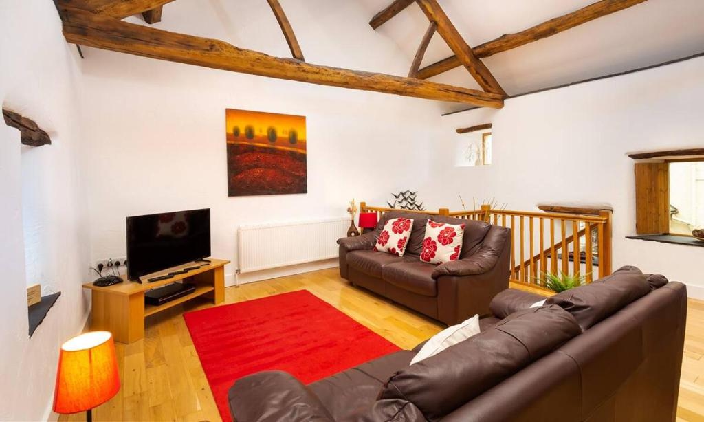 uma sala de estar com um sofá e uma televisão em The Mistal em Newby Bridge