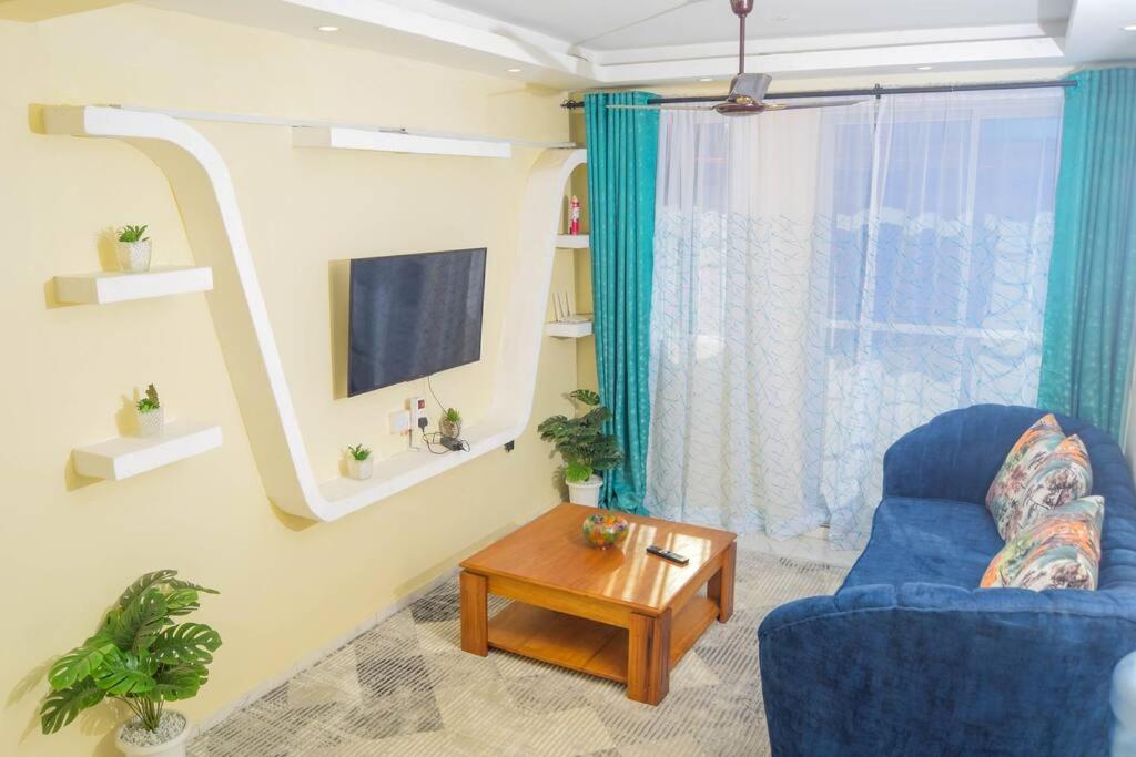 a living room with a blue chair and a table at One bedroom apartment-Bamburi Fisheries0711519879 in Mombasa