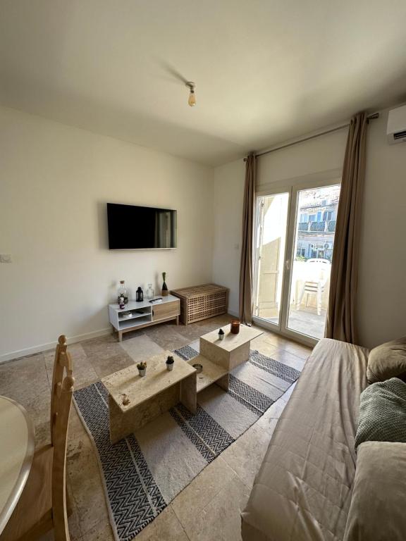 a living room with a couch and a tv at Charmant séjour Marseillais in Marseille
