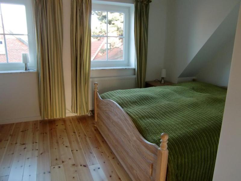 - une chambre avec un lit vert et une fenêtre dans l'établissement Giebelhaus Frida - Sylt, Westerland, à Westerland