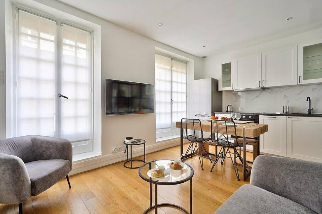 uma cozinha e uma sala de estar com mesa e cadeiras em Magnifique appartement proche Tour Eiffel em Paris