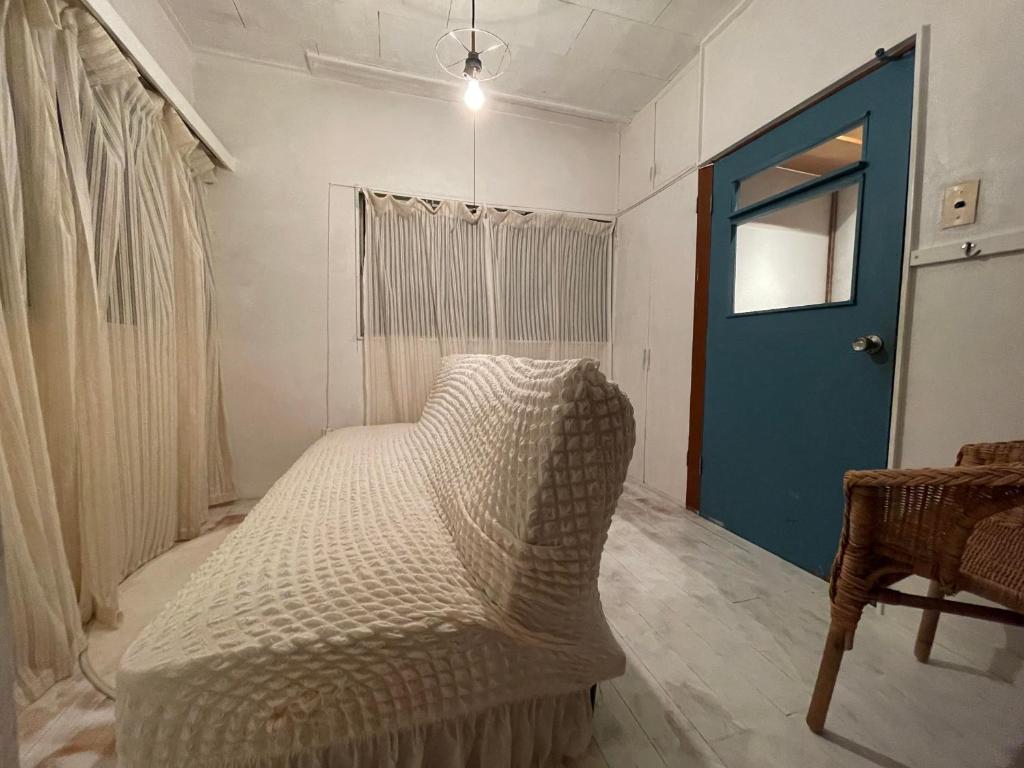 a bed in a room with a blue door at 経堂の小さな一棟貸wakusei in Tokyo