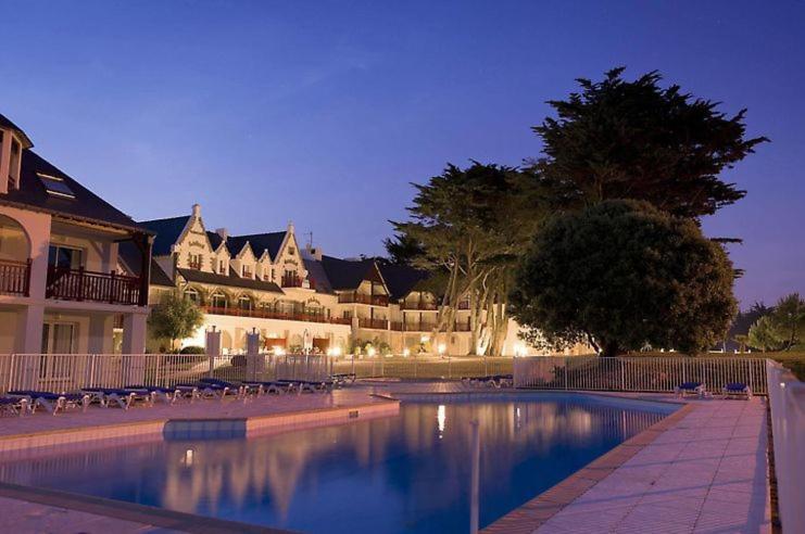 a house with a swimming pool in front of a building at Appartement de Tamaris (4 pers) in Le Pouliguen