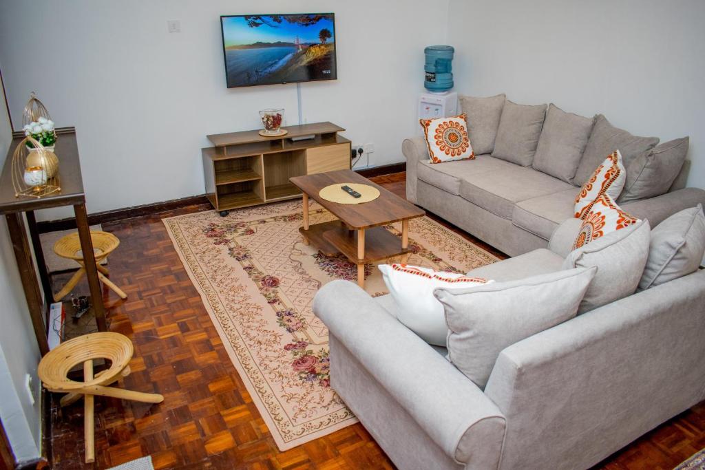 uma sala de estar com um sofá e uma mesa em Classy African - themed 1 BR apartment in Karen em Karen
