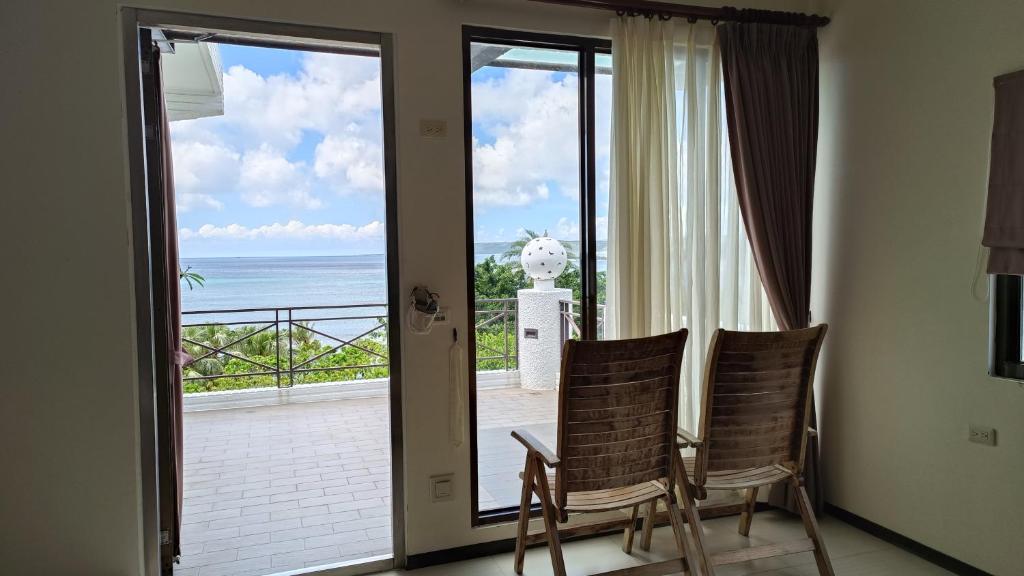 a room with two chairs and a view of the ocean at La View 麗晨 Homestay in Manzhou