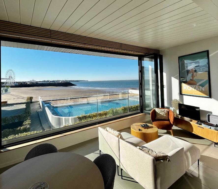 salon z dużym oknem z widokiem na ocean w obiekcie L'Escale SUNRISE panorama sur l'estuaire w mieście Royan