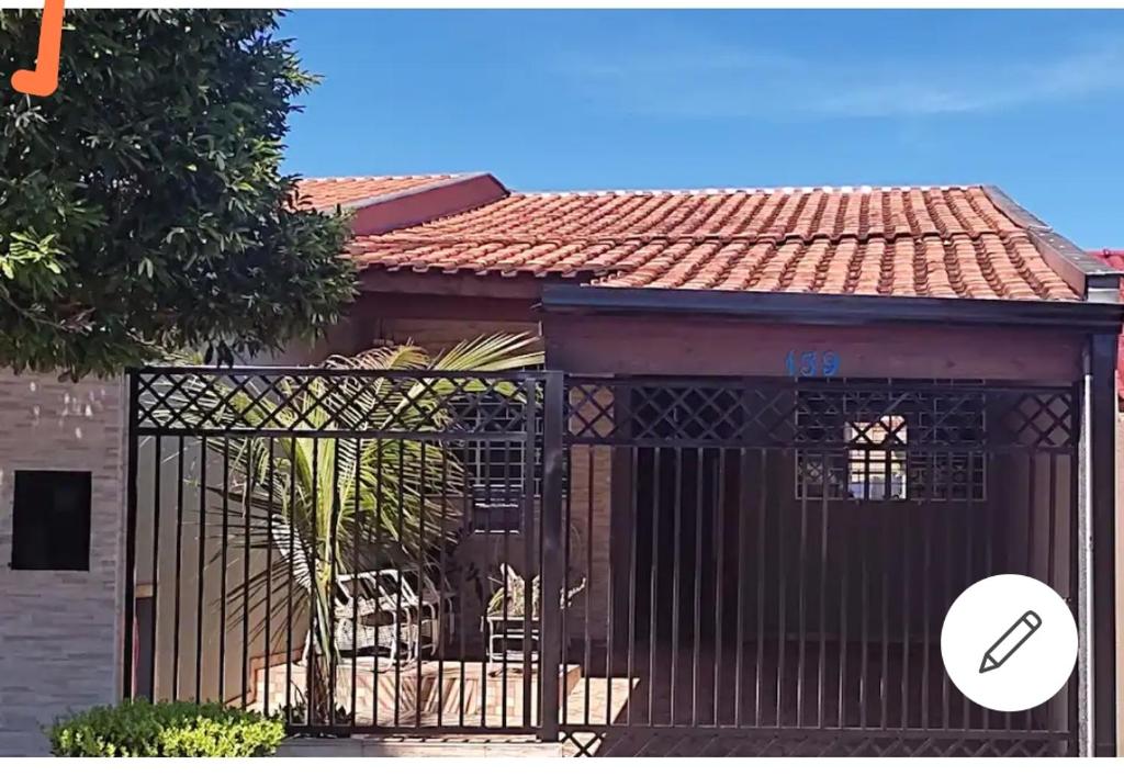 a building with a gate in front of a house at Gray house 1 - Londrina JD. Santiago in Londrina