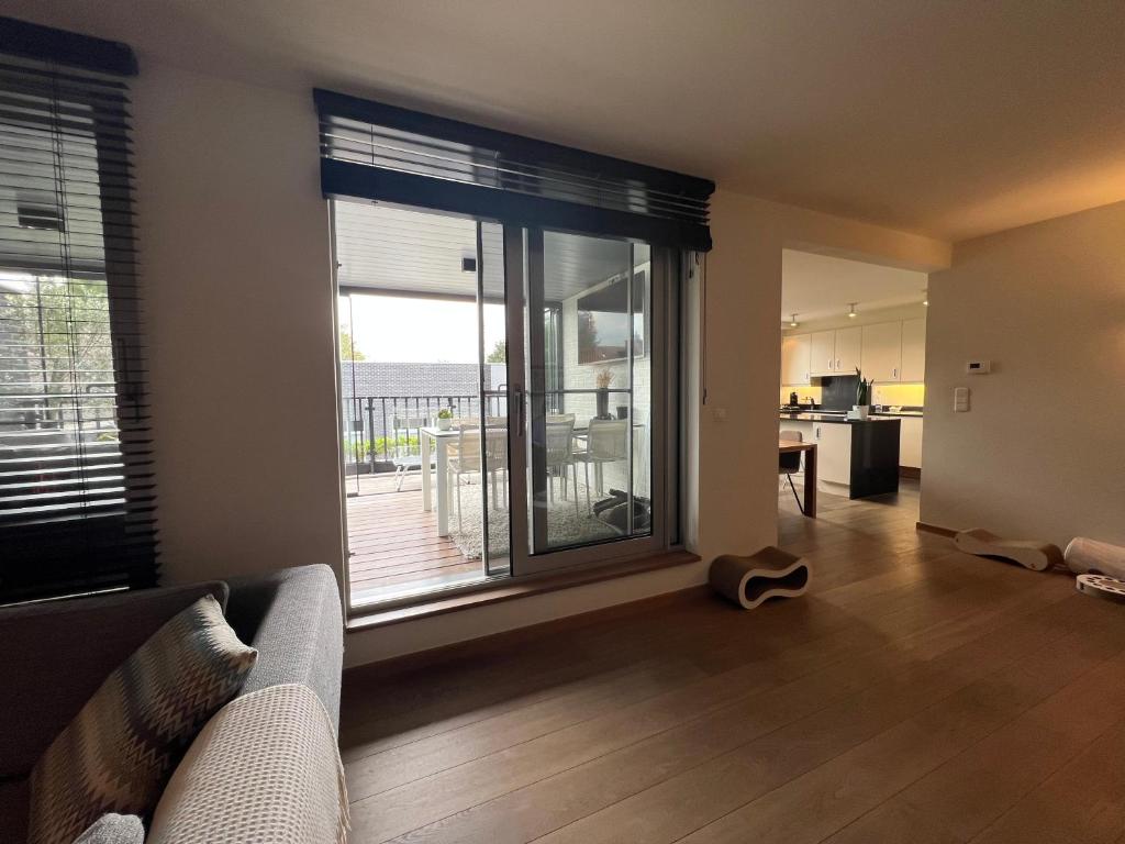 a living room with a couch and a large window at Business Accommodation Luxury XL Geel in Geel