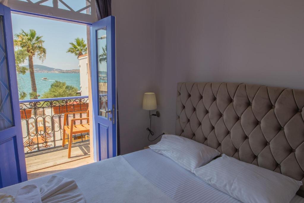 a bedroom with a bed and a view of the ocean at Deniz Önü Guesthouse in Ayvalık