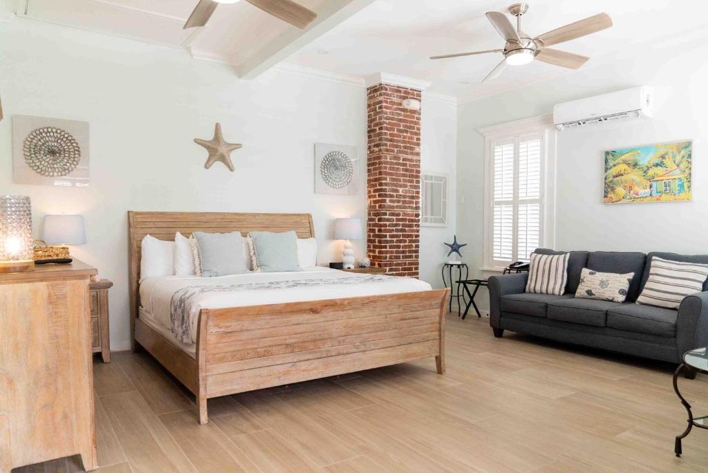 a bedroom with a bed and a couch at Southernmost Point Guest House & Garden Bar in Key West