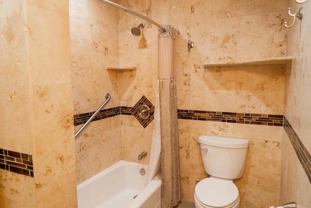 a bathroom with a toilet and a bath tub at Southernmost Point Guest House & Garden Bar in Key West