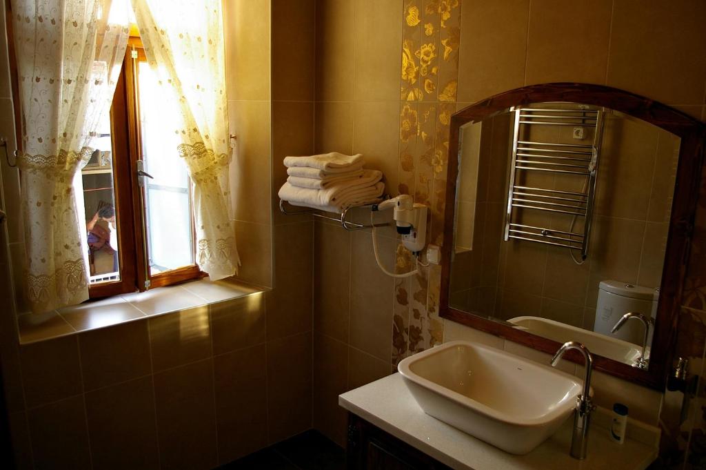 a bathroom with a sink and a mirror and a window at Hera Hotel in Bergama