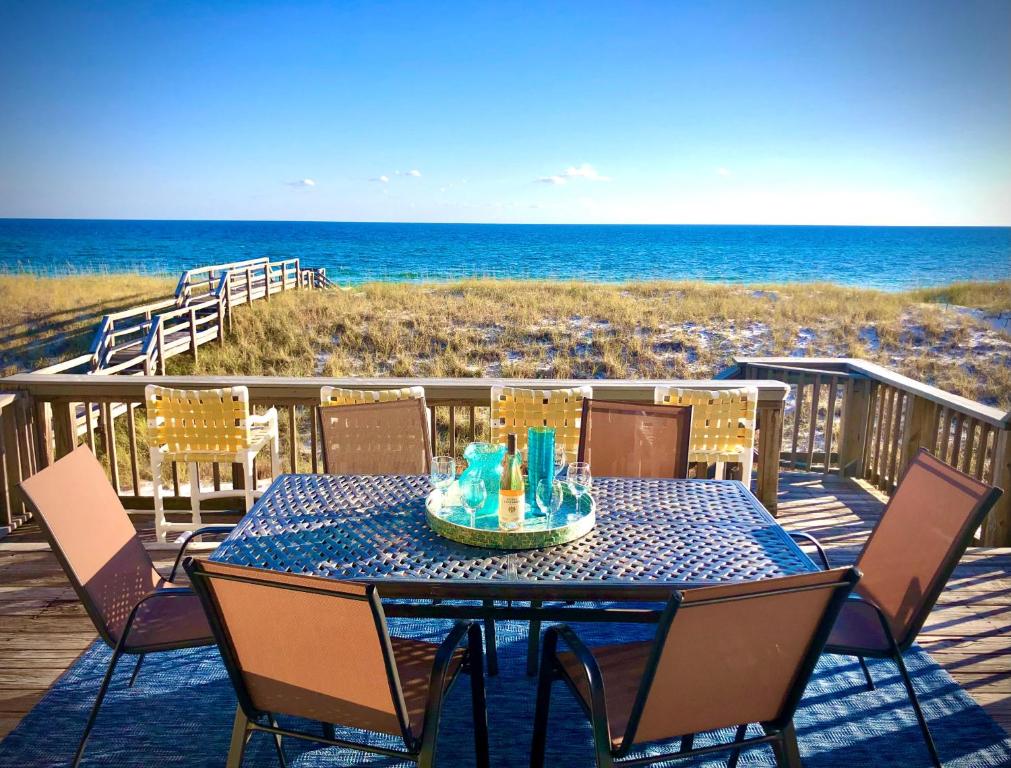 a table on a deck with a view of the beach at Sweet Alice's Sandcastle in Navarre