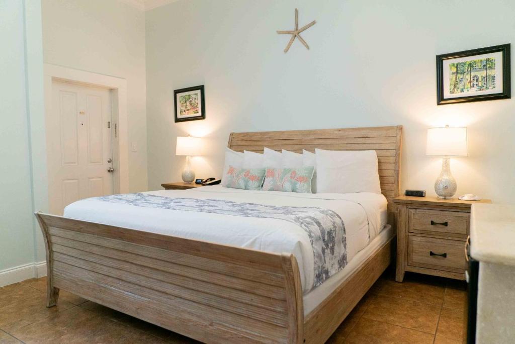a bedroom with a large bed and two night stands at Southernmost Point Guest House & Garden Bar in Key West
