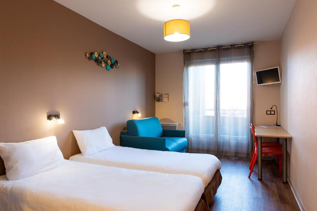 um quarto de hotel com duas camas e uma cadeira azul em Résidence Otellia em Blanquefort