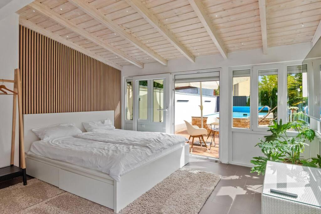 a bedroom with a white bed and a patio at Gästehaus für 3 - Sauna - Terrasse - WLAN - Küche in Haßloch