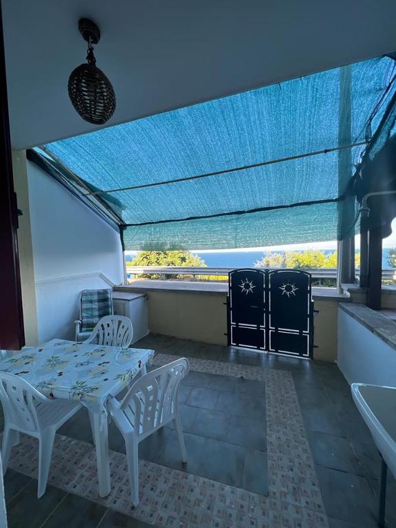 een eetkamer met een tafel en stoelen en een raam bij Casa vacanze di Anna in Corsano