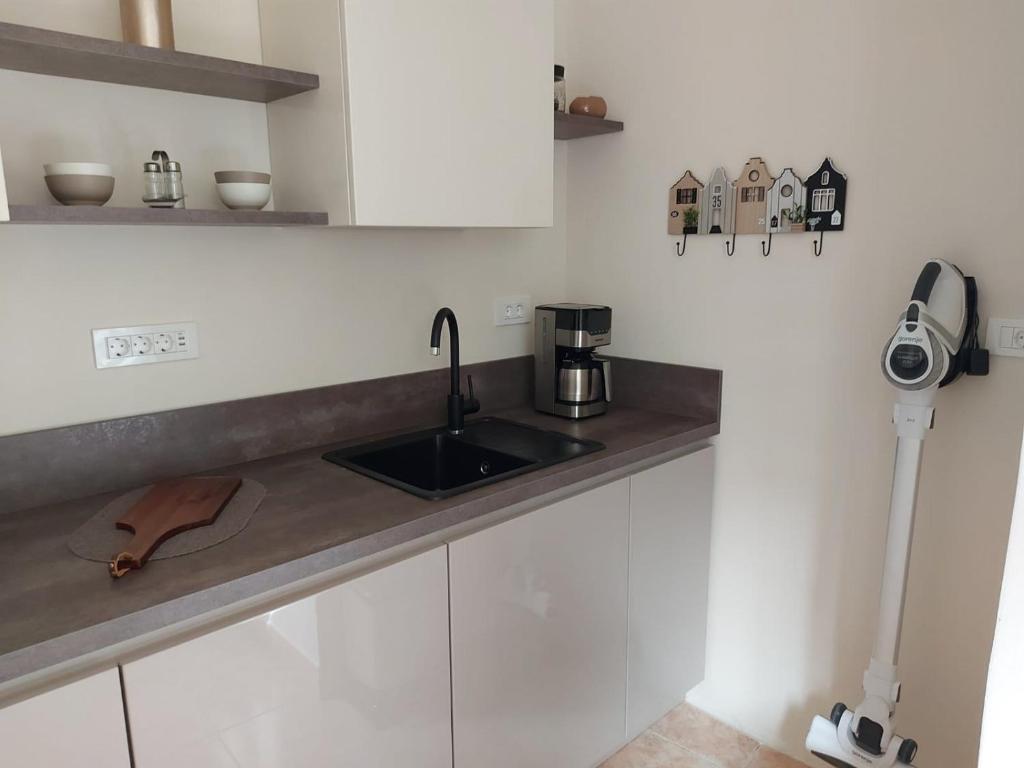a kitchen with white cabinets and a sink at Old city apartment in Rovinj