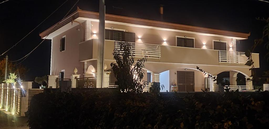 una gran casa blanca por la noche con luces en Villa Mary, en Éboli