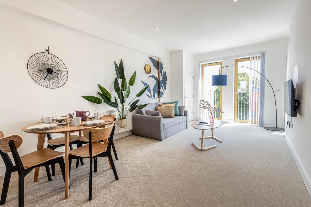 a living room with a table and chairs and a couch at Modern Apartments with Balcony in Merton near Wimbledon by Belvilla in Mitcham
