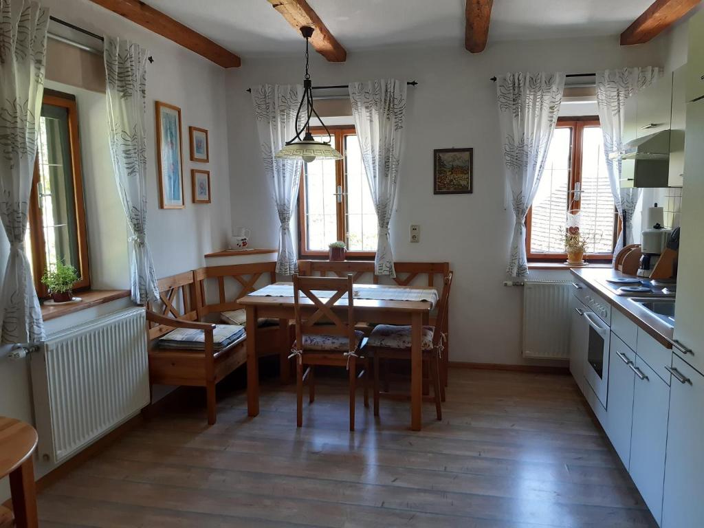 a kitchen with a table and chairs and windows at Nussbaumerhof 