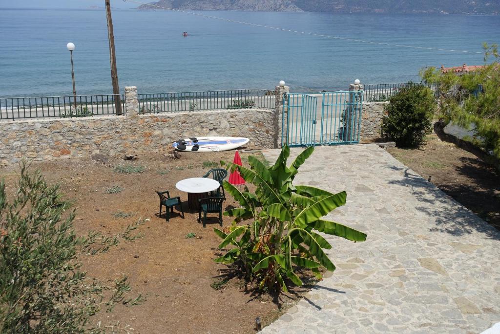 a table and chairs next to the ocean with a fence at Studio in Villa in Kalloni direkt am Meer in Kalloni