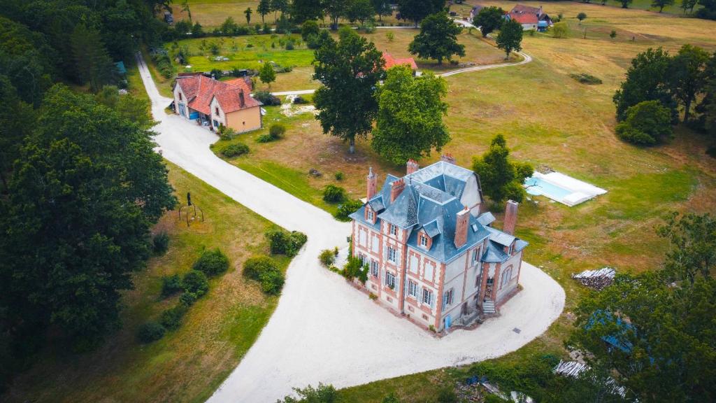 une vue aérienne sur une grande maison avec un toit bleu dans l'établissement La Maison du Garde, domaine de La Drelas, 6 couchages, pierre et bois,, à Chaumont-sur-Tharonne