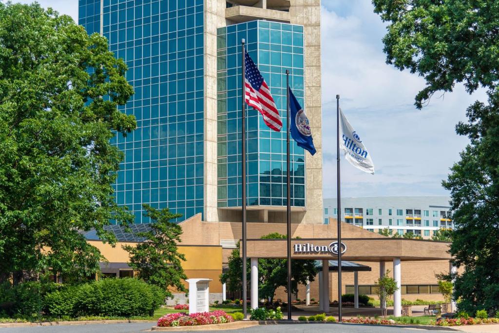 a building with two flags in front of it at Hilton Alexandria Mark Center in Alexandria