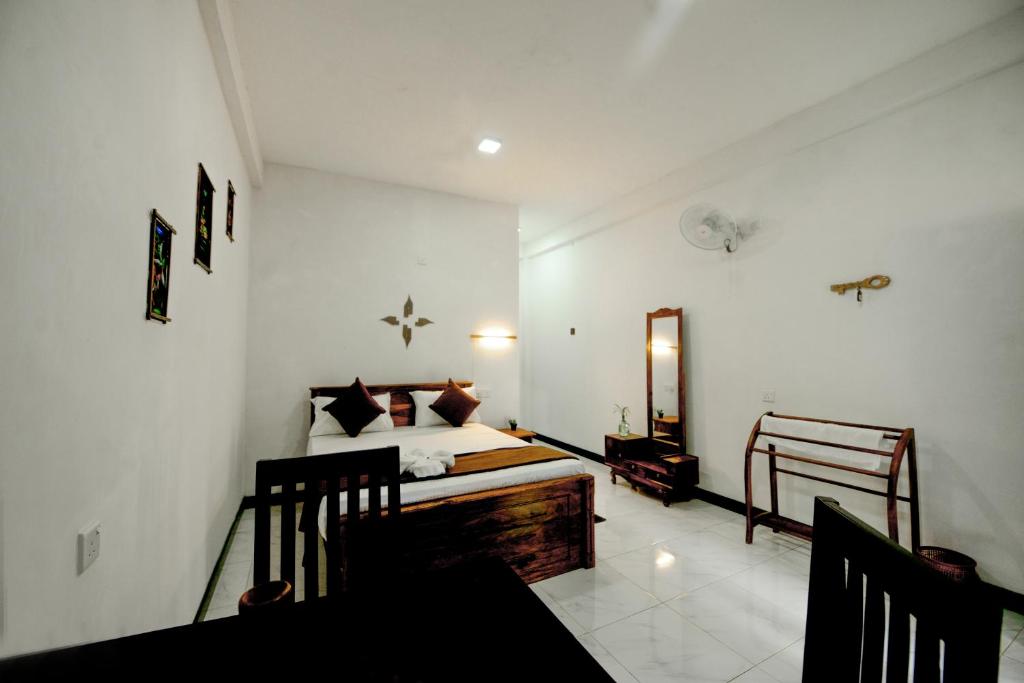 1 dormitorio con cama y espejo. en Dambulla Kings Inn, en Dambulla
