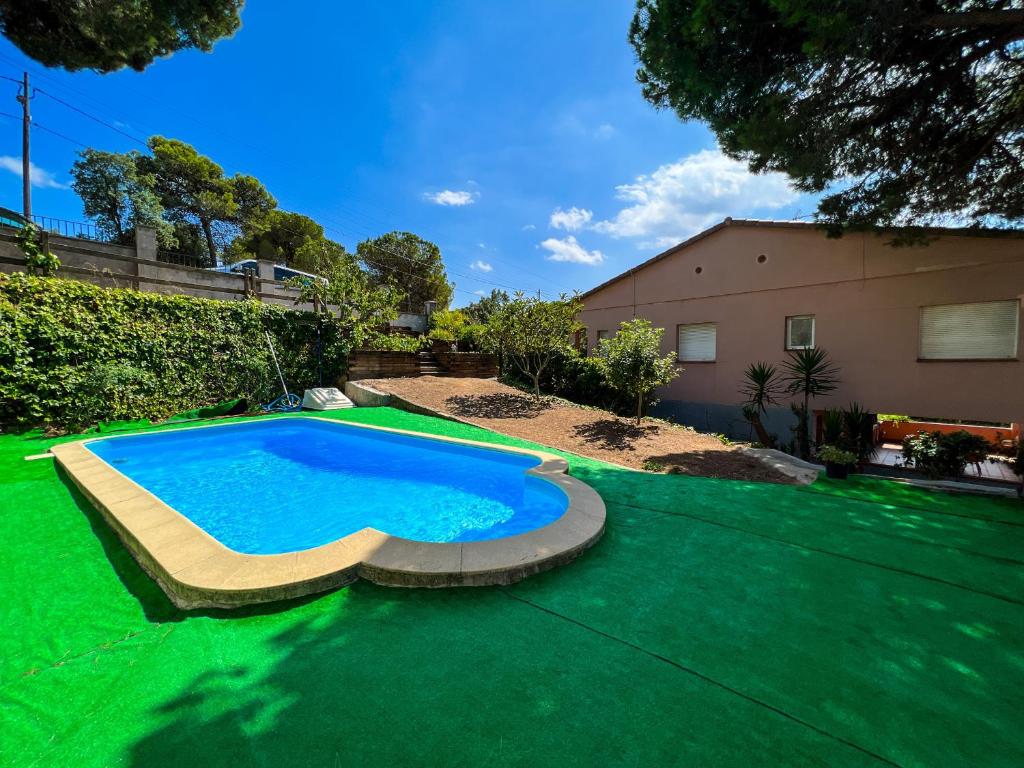 einen Pool im Garten mit grünem Rasen in der Unterkunft Vivalidays Gala in Tordera