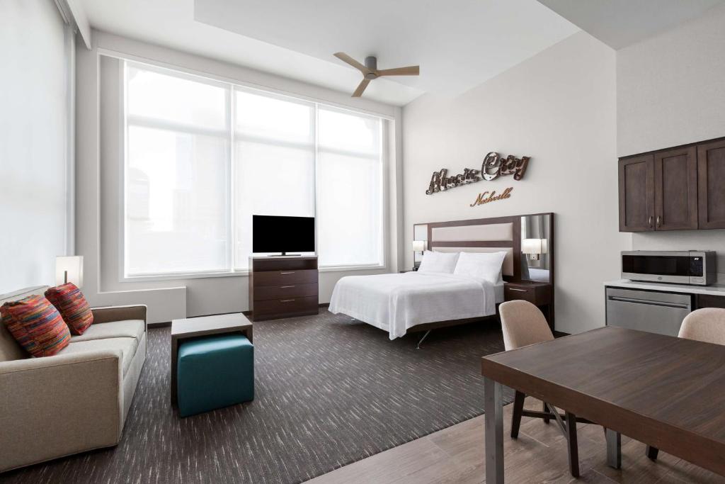 ein Schlafzimmer mit einem Bett und ein Wohnzimmer in der Unterkunft Homewood Suites by Hilton Nashville Downtown in Nashville