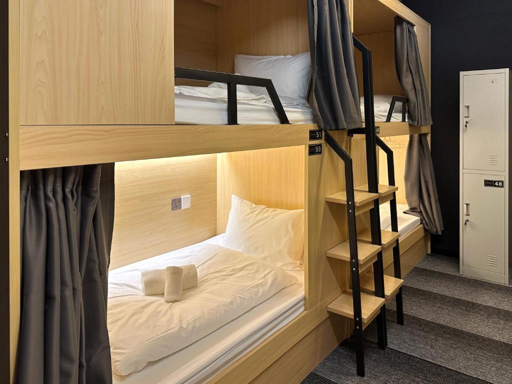 a room with two bunk beds in a room at THE ROOM Capsule Hotel in Singapore