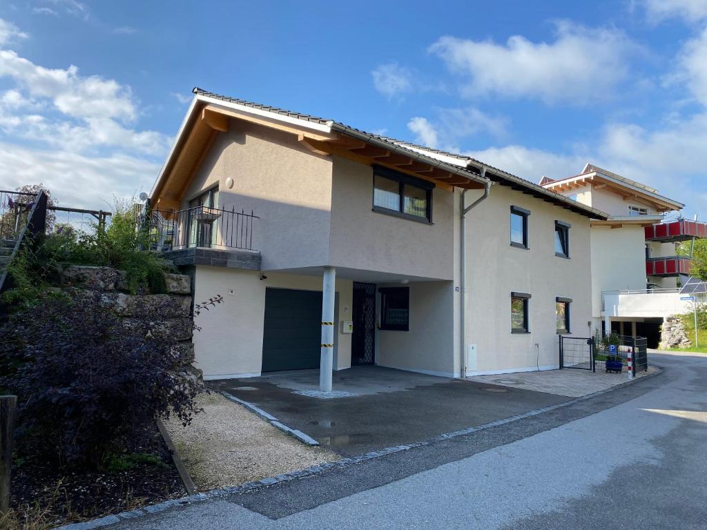 a large white house with a garage at Ferienwohnung mit Salzachblick in Laufen