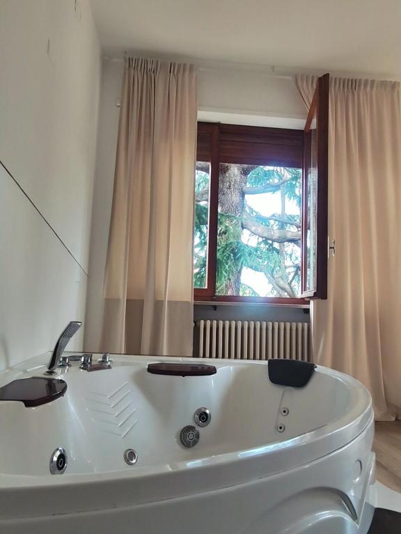 uma banheira branca na casa de banho com uma janela em Villa Cresto em Gaglianico