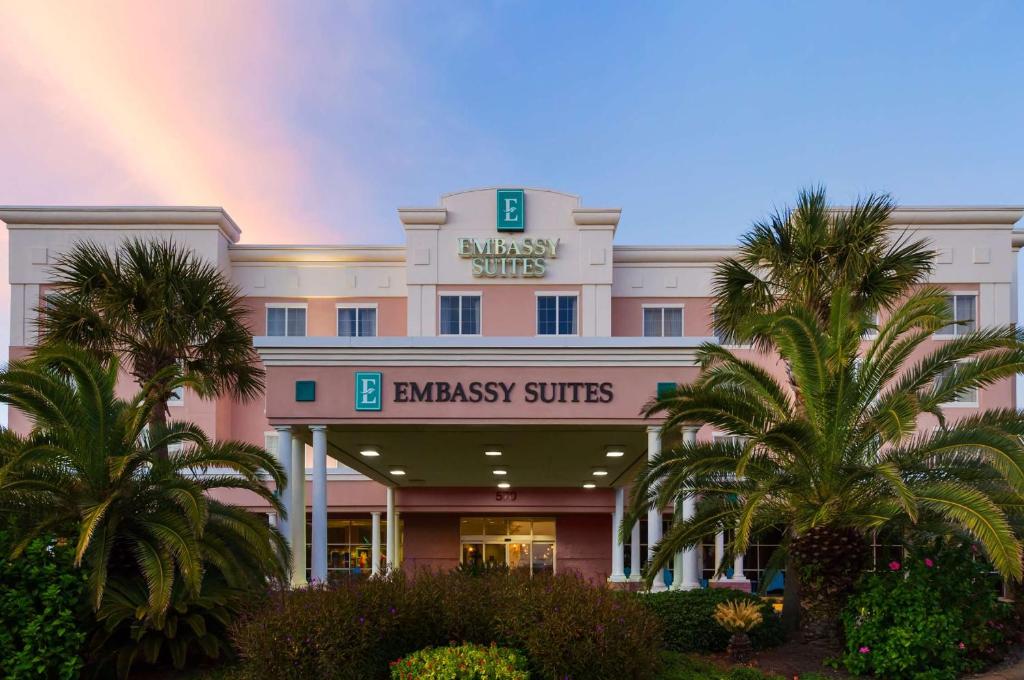 a large white building with a rainbow in the sky at Embassy Suites by Hilton Destin Miramar Beach in Destin