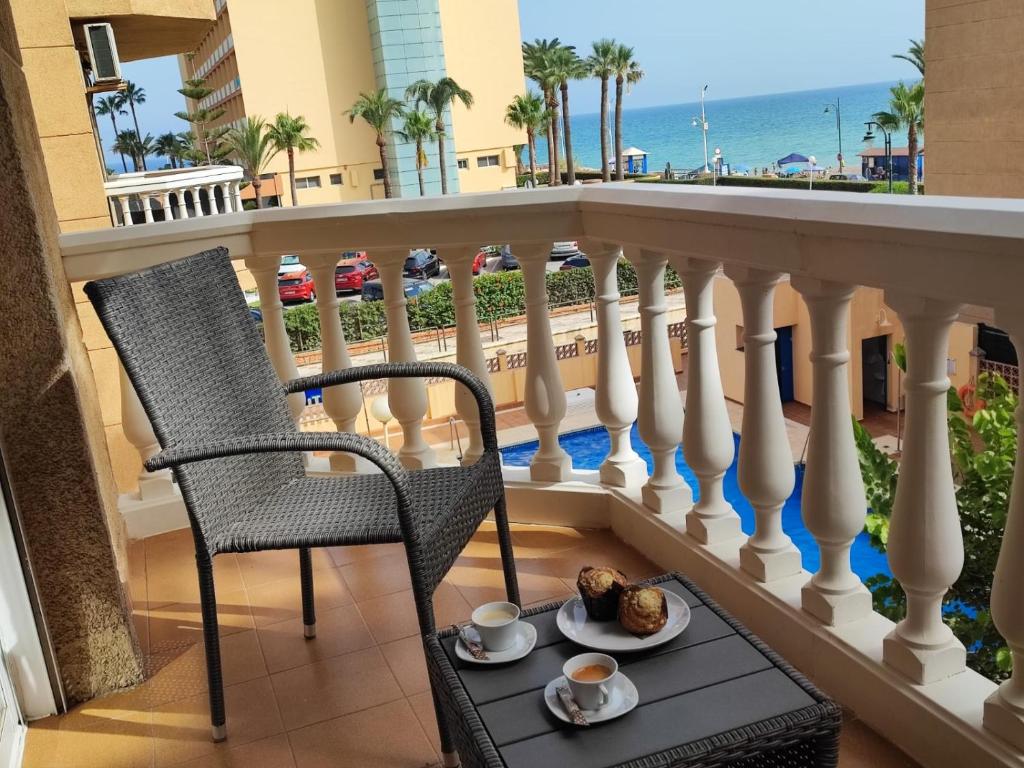 a balcony with a chair and a plate of food at Casa Playa Guadalmar in Málaga