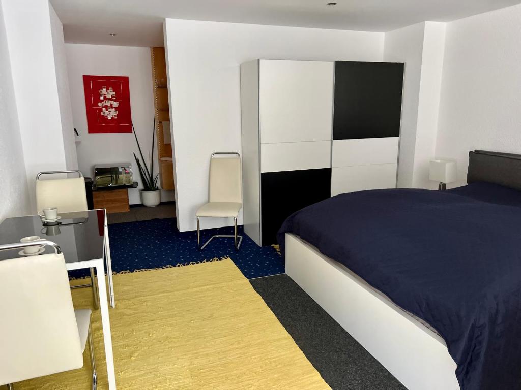 a bedroom with a bed and two chairs in it at Glads Apartment in Feldkirch