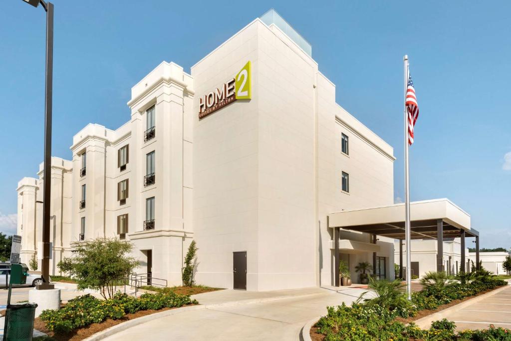 Home2 Suites by Hilton Parc Lafayette في لافاييت: مبنى مكتب مع علامة المكيز عليه