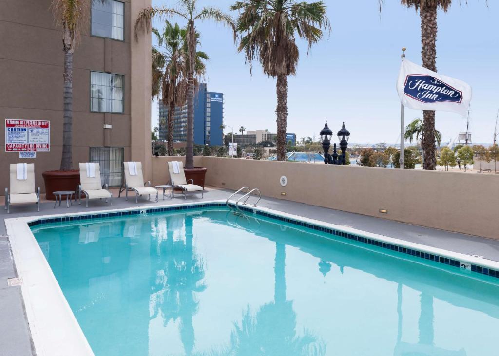 a large swimming pool with chairs and palm trees at Hampton Inn San Diego Downtown in San Diego