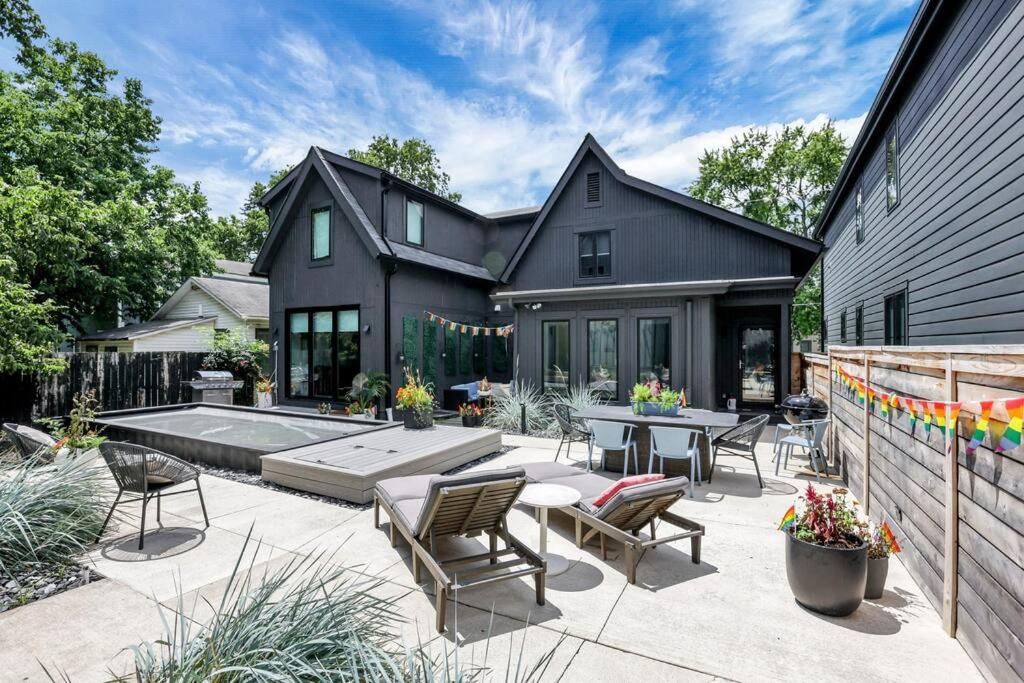 a black house with a patio and a swimming pool at Stylish Nexus in Columbus