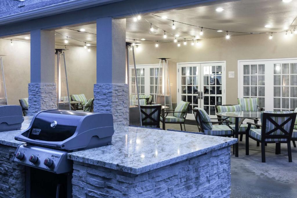 - un barbecue sur une terrasse avec des tables et des chaises dans l'établissement Homewood Suites by Hilton Seattle-Tacoma Airport/Tukwila, à Tukwila