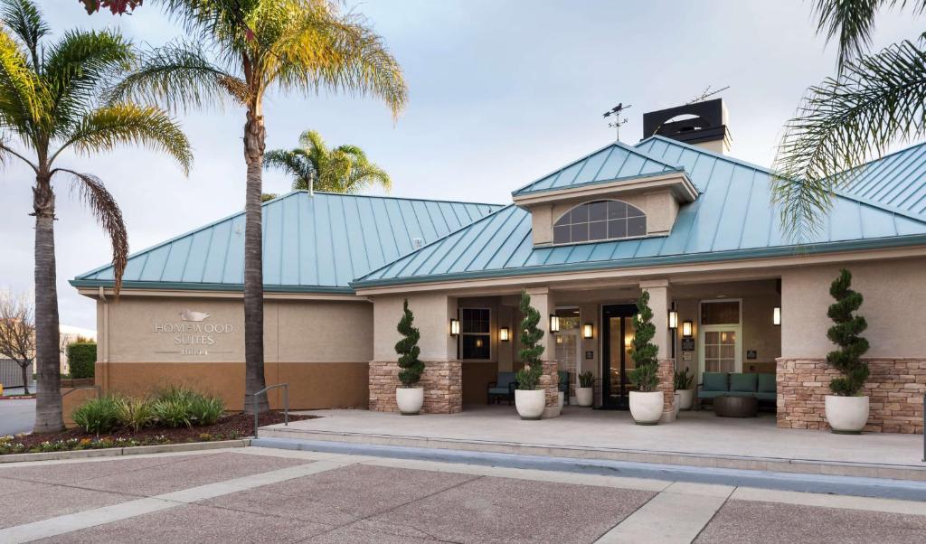 a building with a blue roof with palm trees at Homewood Suites by Hilton San Jose Airport-Silicon Valley in San Jose