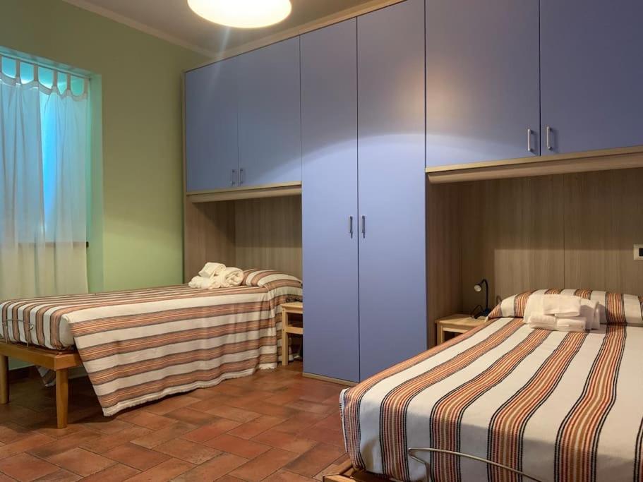 Habitación con 2 camas y armarios azules. en Dall’Artemio - appartamento a Sillico, en Sillico